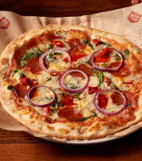 A MOD pizza with pepperoni, spinach, and onion toppings