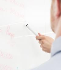 An office worker looking at a figures on a whiteboard